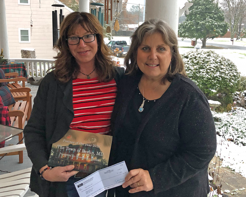 Ivy Wells, Economic Development Coordinator receives $1000 donation from Chesapeake Ghost's owner, Mindie Burgoyne